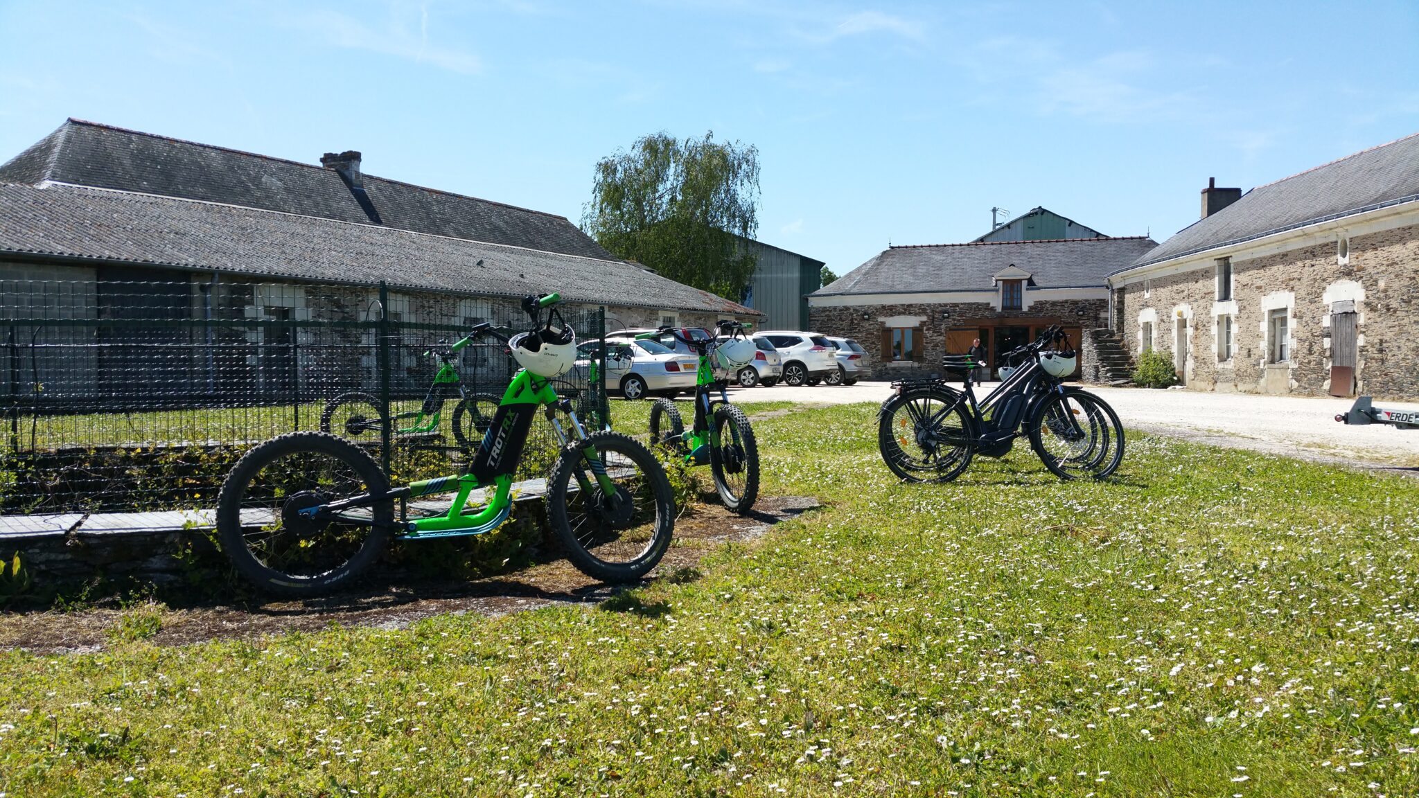Vélos électriques stationnés ferme ensoleillée.